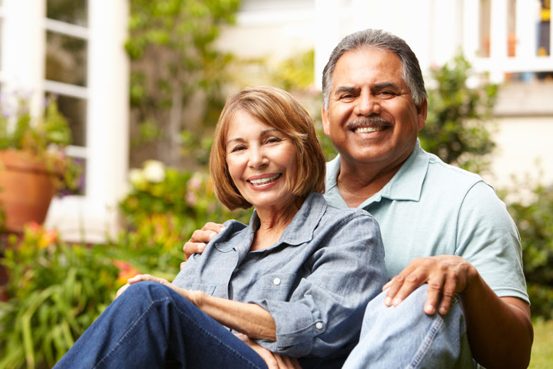 two dental implant patients smiling together with dental implants.