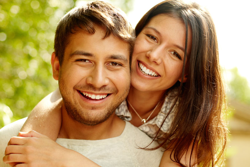 dental implant patients smiling after smile restoration treatment.