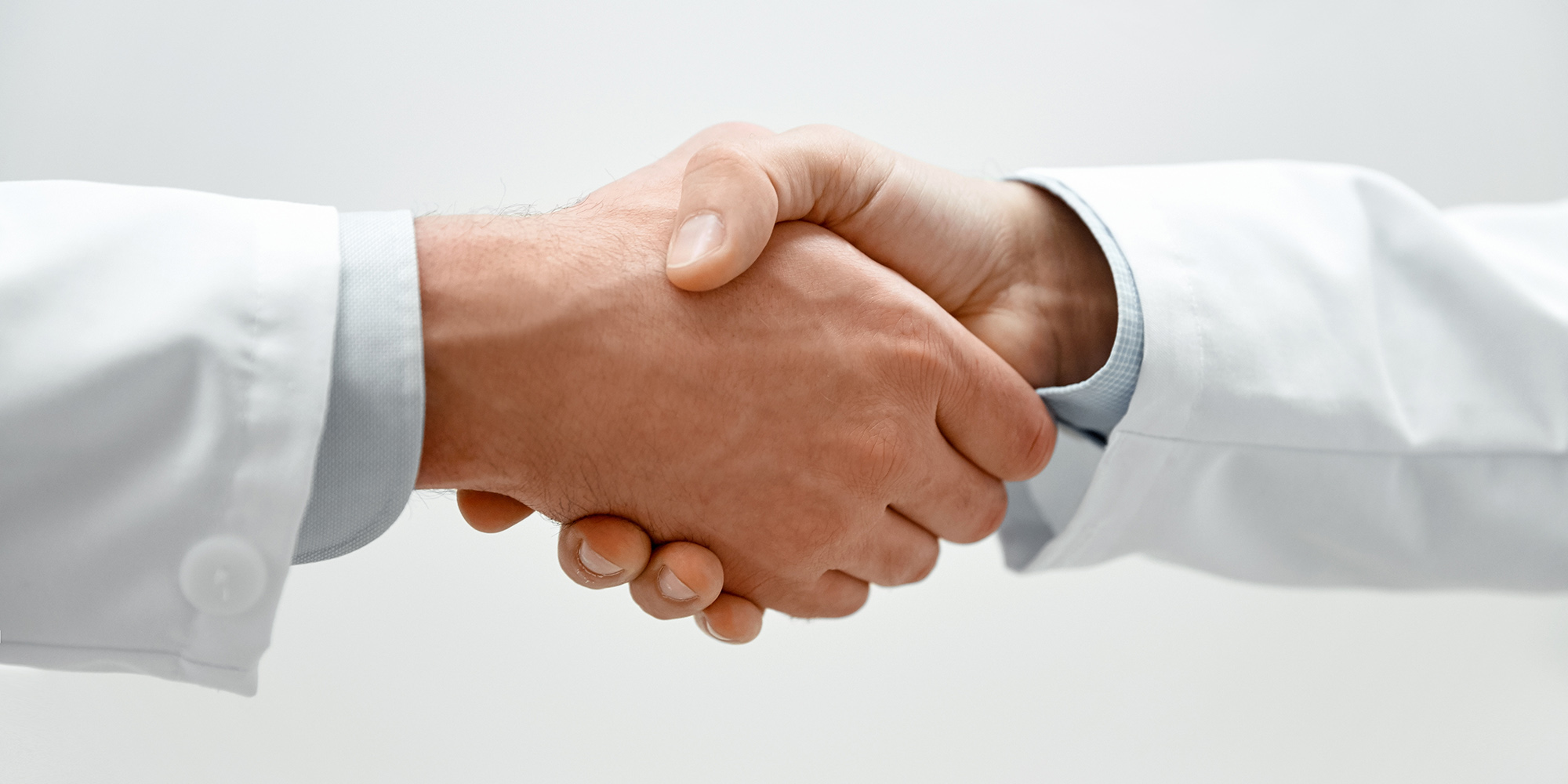 close up of two male doctors shaking hands